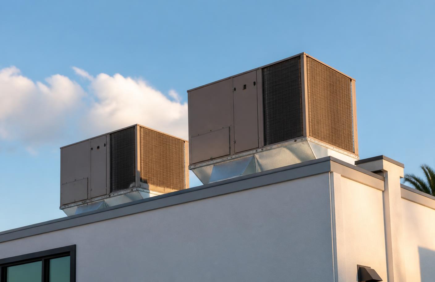 Rooftop packaged HVAC units on a low commercial building under a clear Florida sky